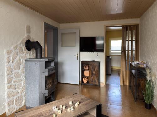 a living room with a fireplace and a table at Ferienhaus in Altenfeld Thüringen mit Garten in Altenfeld