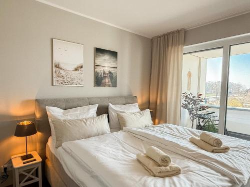 a bedroom with a large white bed with towels on it at Ferienwohnung Seeglück am Dümmer See in Lembruch