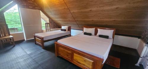 a bedroom with two beds in a wooden cabin at Sigiriya River Side Resort in Sigiriya