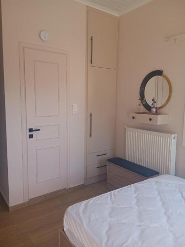 ein Schlafzimmer mit einem Bett, einer Tür und einem Spiegel in der Unterkunft Angelos Apartment in Vathy