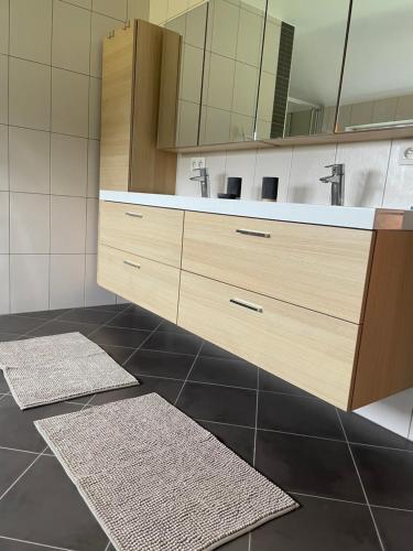 a bathroom with a sink and two rugs on the floor at Le Daguet pour 8 in Florenville