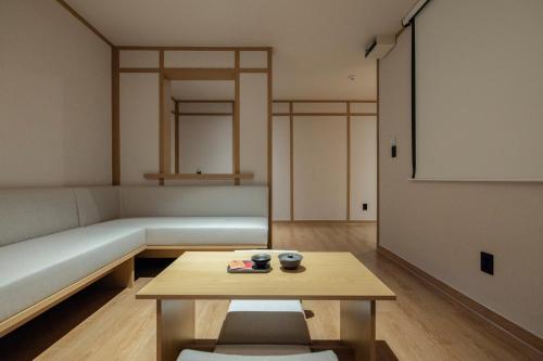 a living room with a couch and a table at Anook Ryokan Hotel Daejeon Yuseong in Daejeon