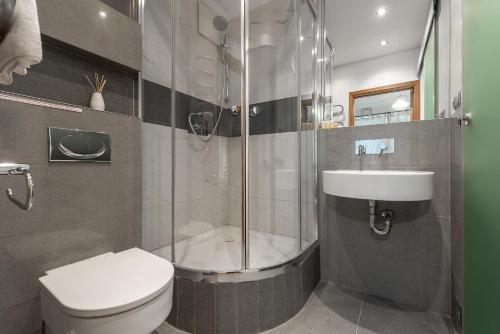 een badkamer met een douche, een toilet en een wastafel bij Dworzec Gdanski P&O Apartments in Warschau