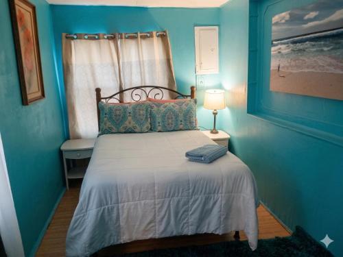 a blue bedroom with a bed and a window at GpL 4134 Cozy & Spacious 4BR Shared House in Fort Myers