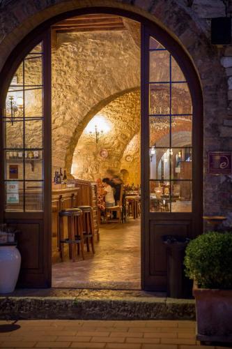 an arched doorway to a restaurant with a table at Borgo Il Poggiaccio Residenza d'Epoca in Sovicille