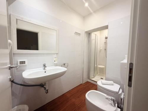 a white bathroom with a sink and a toilet at MH Hotel Maracaibo in Rimini