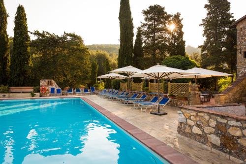 a swimming pool with chairs and umbrellas at Borgo Il Poggiaccio Residenza d'Epoca in Sovicille