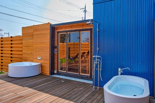 a blue building with a tub on a deck at IZA moriyama in Moriyama