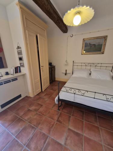 ein Schlafzimmer mit einem Bett und einem gefliesten Boden in der Unterkunft Il Giarolo in Cameriano
