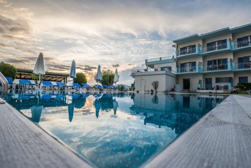 a swimming pool in front of a hotel at Cliff Bay Hotel by GHH in Paleros