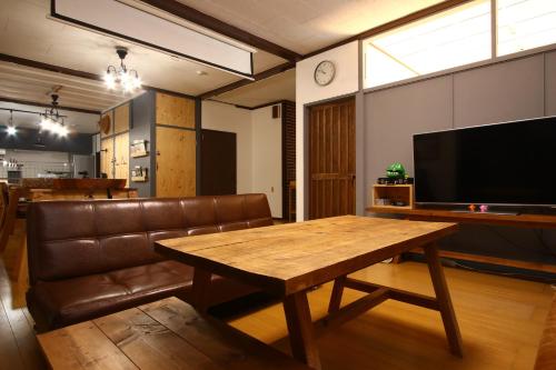 a living room with a wooden table and a couch at オリエンタルヴィラ美崎 in Ishigaki Island