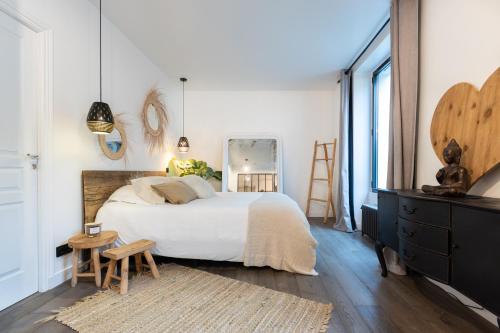 a bedroom with a bed and a dresser and a mirror at Villa cosy Paris in La Garenne-Colombes