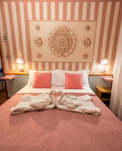 a bed with two towels on top of it at MH Hotel Maracaibo in Rimini