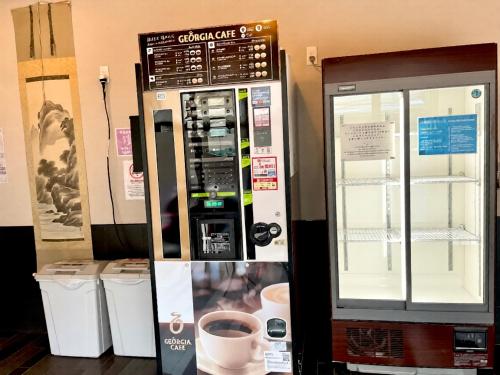 a coffee vending machine with a cup in it at Yoroi Asakusa Hotel in Tokyo