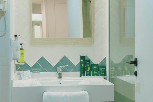 a bathroom with a sink and a mirror at Sercotel Carlos III in Cartagena