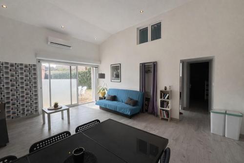 a living room with a blue couch and a table at La Maisonette à Lacrost in Lacrost