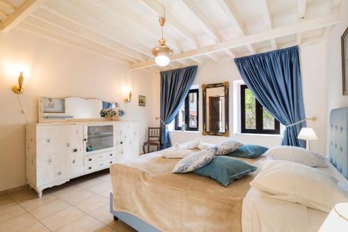 a bedroom with a large bed with blue curtains at Kristina´s Apartments in Rhodes Town