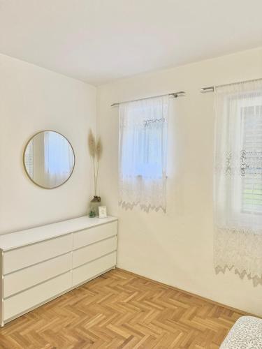 a white room with a dresser and a mirror at Apartment Olivia in Šmrika