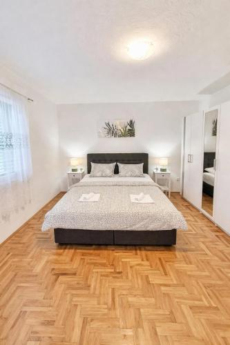 a bedroom with a bed and a wooden floor at Apartment Olivia in Šmrika