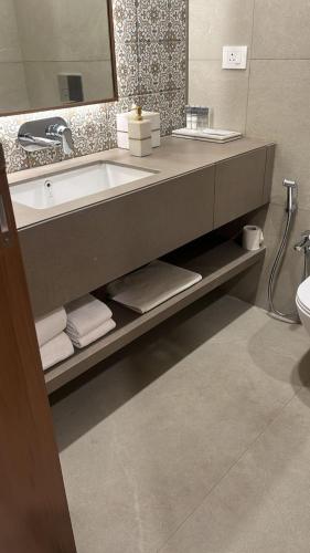 a bathroom with a sink and a counter with towels at Dhiraj Dham in Nāthdwāra