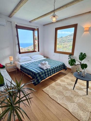 a bedroom with a bed and two windows at Apple Orchard Pelion in Volos