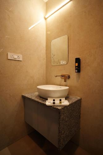 a bathroom with a sink and a mirror on a counter at Hotel JMS Grand in Jaunpur
