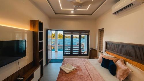 a bedroom with a large bed and a television at Willostays Tamarind beach villa in Cherai Beach