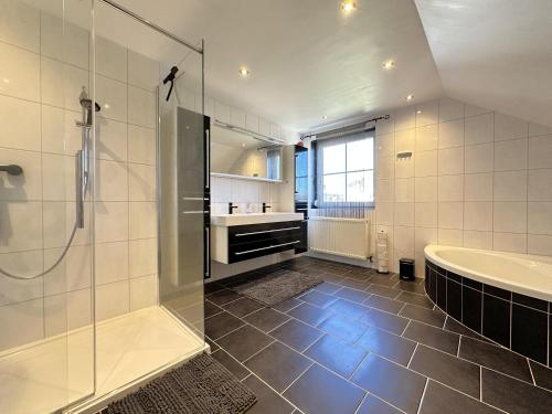 a bathroom with a shower and a tub and a sink at Charly`s Place in Rain