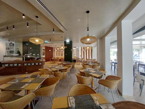 a restaurant with wooden tables and chairs and lights at AP Victoria Sports & Beach in Albufeira