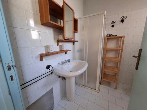 a white bathroom with a sink and a shower at Le Villette Li Sarruni by SalentoInVacanzaCOM in Lido Marini
