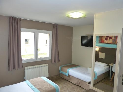 a small room with two beds and a mirror at Hotel ARBOR - Les Hunaudieres - Le Mans Sud - Mulsanne in Mulsanne