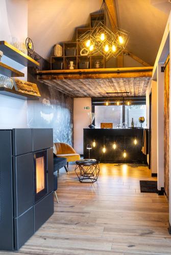a living room with a fireplace and a table at Osé in Chênet