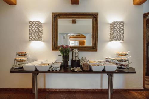 a table with white bowls on it with a mirror at Hotel Lerch in Sankt Johann im Pongau