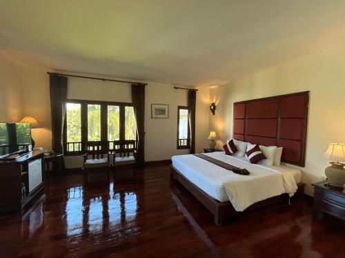 a bedroom with a large bed in a room at Teak Garden Resort, Chiang Rai in Chiang Rai
