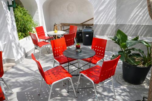 a group of red chairs and a table on a patio at Relax Guesthouse & Hostel Lagos Central in Lagos