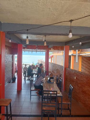 a restaurant with tables and people sitting at tables at Thenewgoldensunrise in Tuktuk Siadong