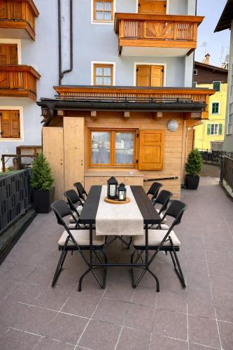 a table and chairs on a patio in front of a building at Appartamento LO SCOIATTOLO in Andalo
