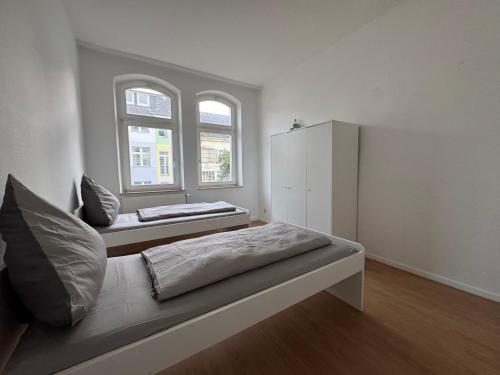 a white room with a bed and a window at Living - Ferien & Monteur Appartement in Wuppertal