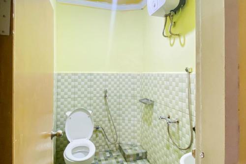 a small bathroom with a toilet and a shower at RedDoorz Syariah At Hotel Matahari 1 Jambi in Jambi