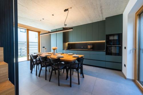 a dining room with a wooden table and black chairs at The Alpine House Otto in Begunje na Gorenjskem