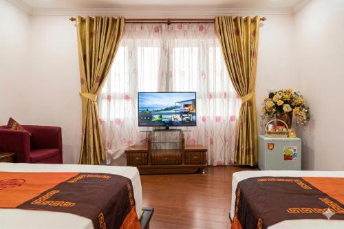 a hotel room with two beds and a flat screen tv at Urban Alley Hotel in Hanoi