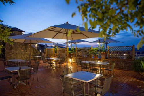 a group of tables with umbrellas on a patio at Borgo Il Poggiaccio Residenza d'Epoca in Sovicille