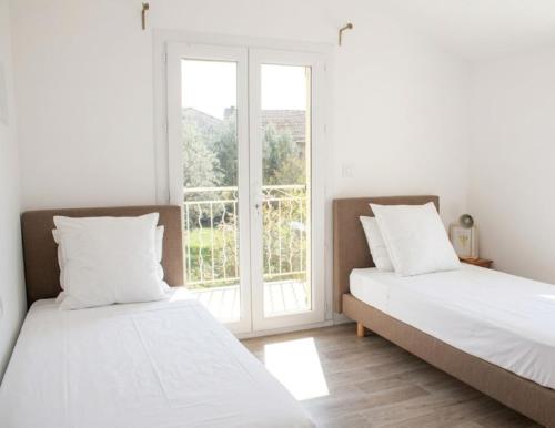 two beds in a room with a window at La villa Cigaliere in Tulette