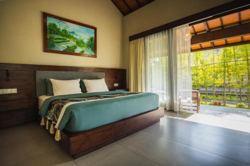 a bedroom with a bed and a large window at K Ko Surf Village at Keramas in Lebih