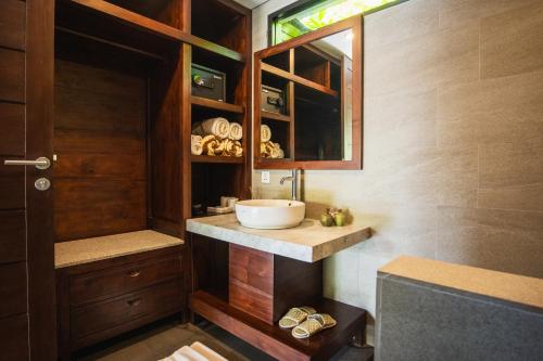a bathroom with a sink and a mirror at K Ko Surf Village at Keramas in Lebih