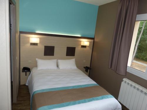 a bedroom with a white bed with a window at Hotel ARBOR - Les Hunaudieres - Le Mans Sud - Mulsanne in Mulsanne