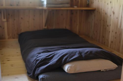 a bed in a room with a pillow on the floor at Lotus Retreat ロータスリトリート 高知空港から車で30分 山のふもとの一棟貸しコテージ in Kami