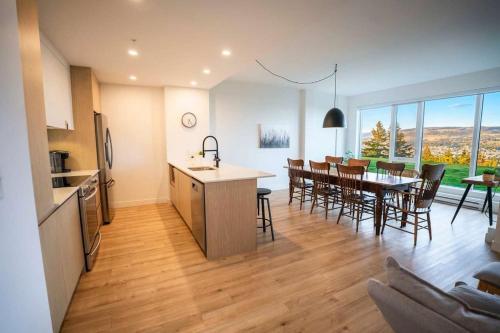 a kitchen and living room with a table and chairs at Chic Condo - Stunning View & Quiet in Baie-Saint-Paul