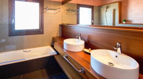 a bathroom with a sink and a mirror and a tub at LES FEIXES LLARGUES - max 18 pax in Bolvir