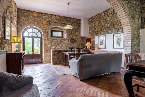 a living room with a stone wall at Podere le Lune with Pool, San Gimignano in San Gimignano